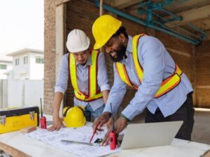 Construction survey crew measuring elevation and layout points on a sloped lot for building and infrastructure expansion